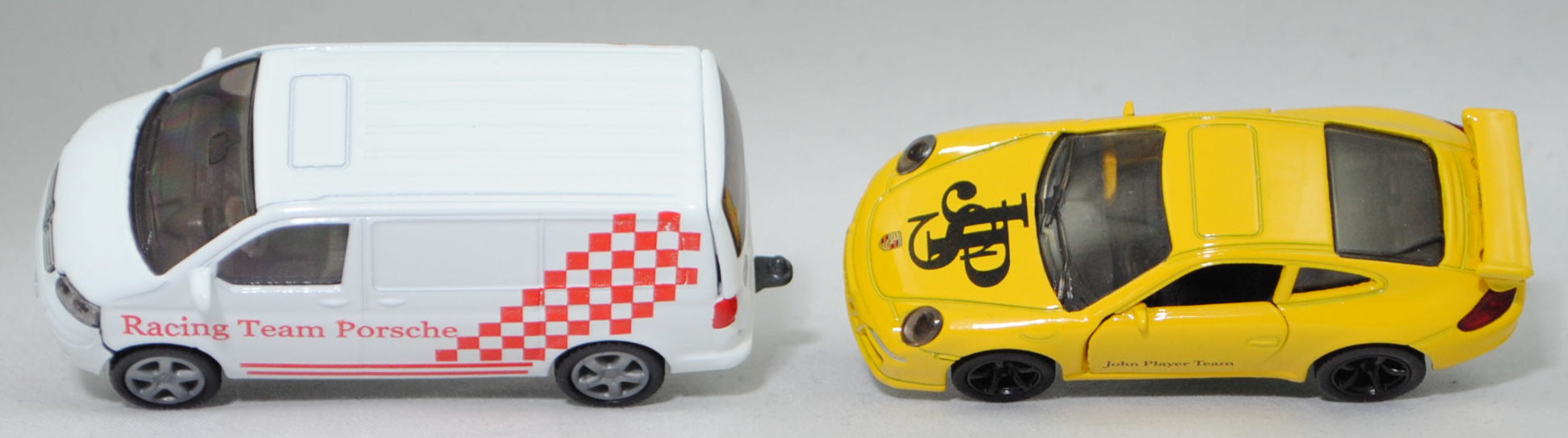 00409 VW T5.1 Transporter Kastenwagen 3.2 V6 4MOTION® mit Porsche 911 Carrera S, weiß, Racing Team Porsche + gelb, John Player Team / JPS , SIKU SUPER 1:55, m