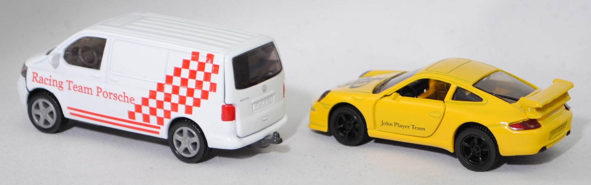 00409 VW T5.1 Transporter Kastenwagen 3.2 V6 4MOTION® mit Porsche 911 Carrera S, weiß, Racing Team Porsche + gelb, John Player Team / JPS , SIKU SUPER 1:55, m