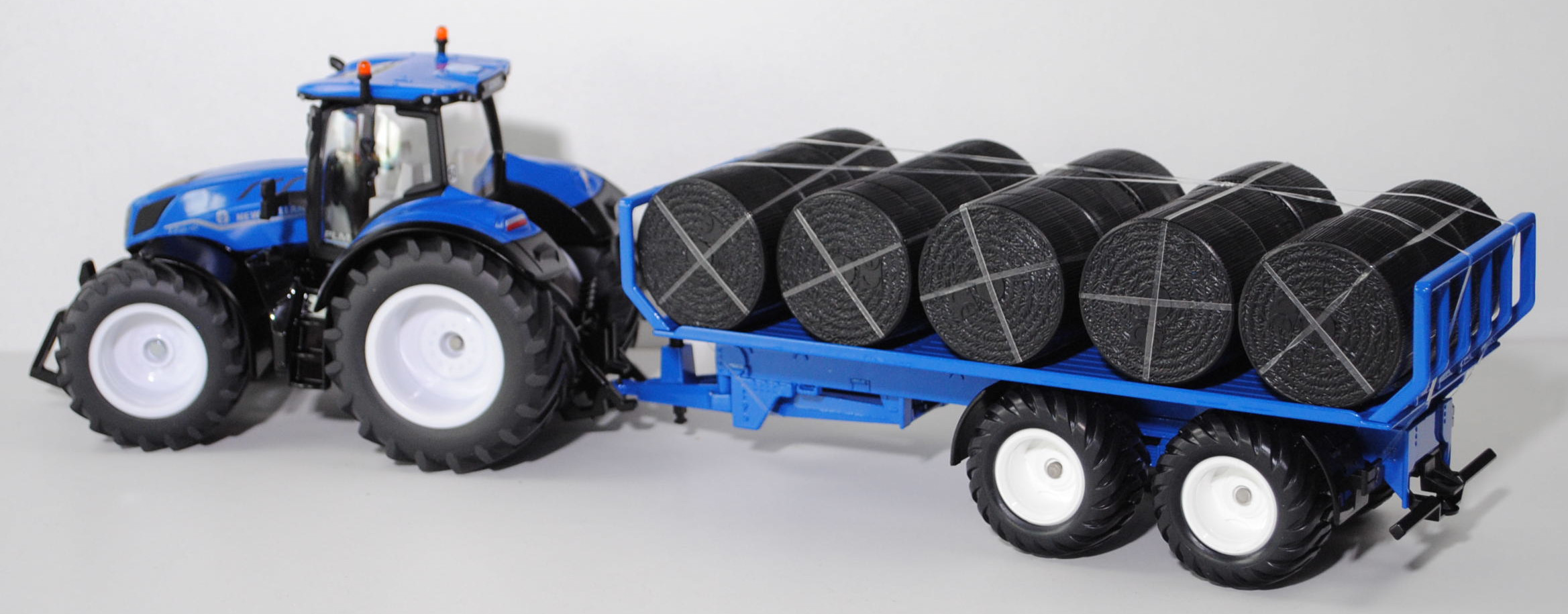 00700 IE + GB New Holland T7.315 HD AC New Generation (Modell 2021-) mit Rundballenanhänger, blau/schwarz, Ladegut: Rundballen schwarz, SIKU FARMER 1:32, L17mpK (Limited)