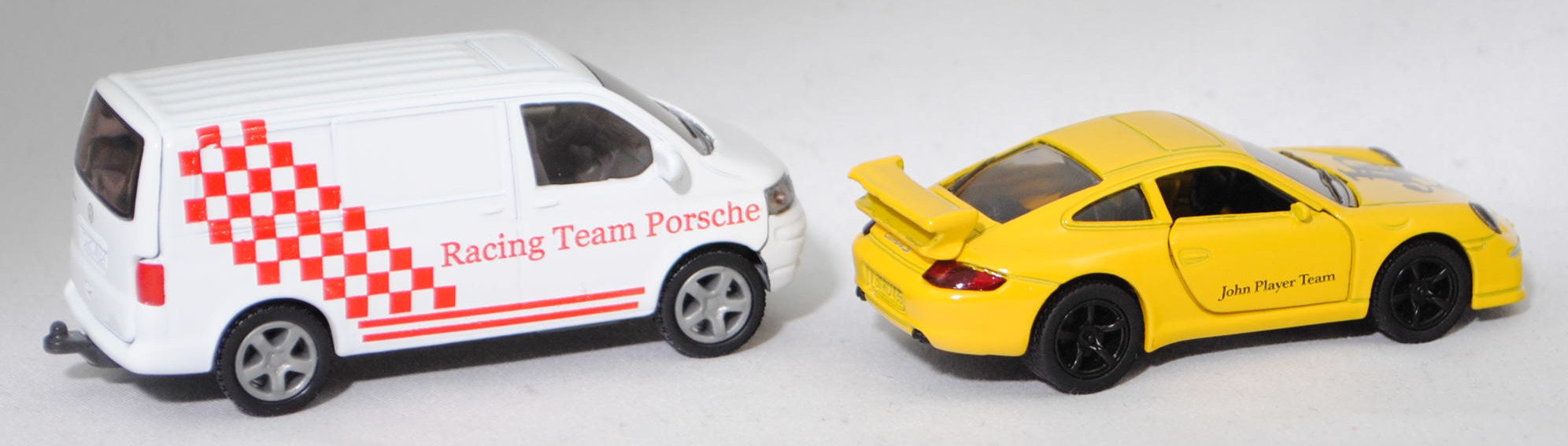 00409 VW T5.1 Transporter Kastenwagen 3.2 V6 4MOTION® mit Porsche 911 Carrera S, weiß, Racing Team Porsche + gelb, John Player Team / JPS , SIKU SUPER 1:55, m