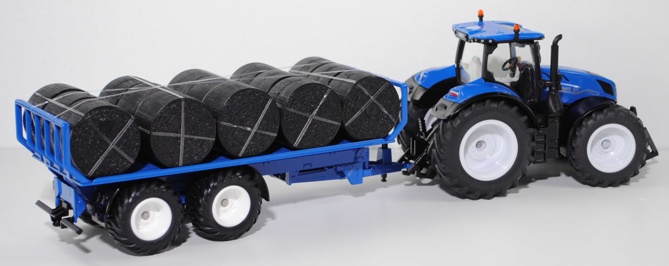 00700 IE + GB New Holland T7.315 HD AC New Generation (Modell 2021-) mit Rundballenanhänger, blau/schwarz, Ladegut: Rundballen schwarz, SIKU FARMER 1:32, L17mpK (Limited)